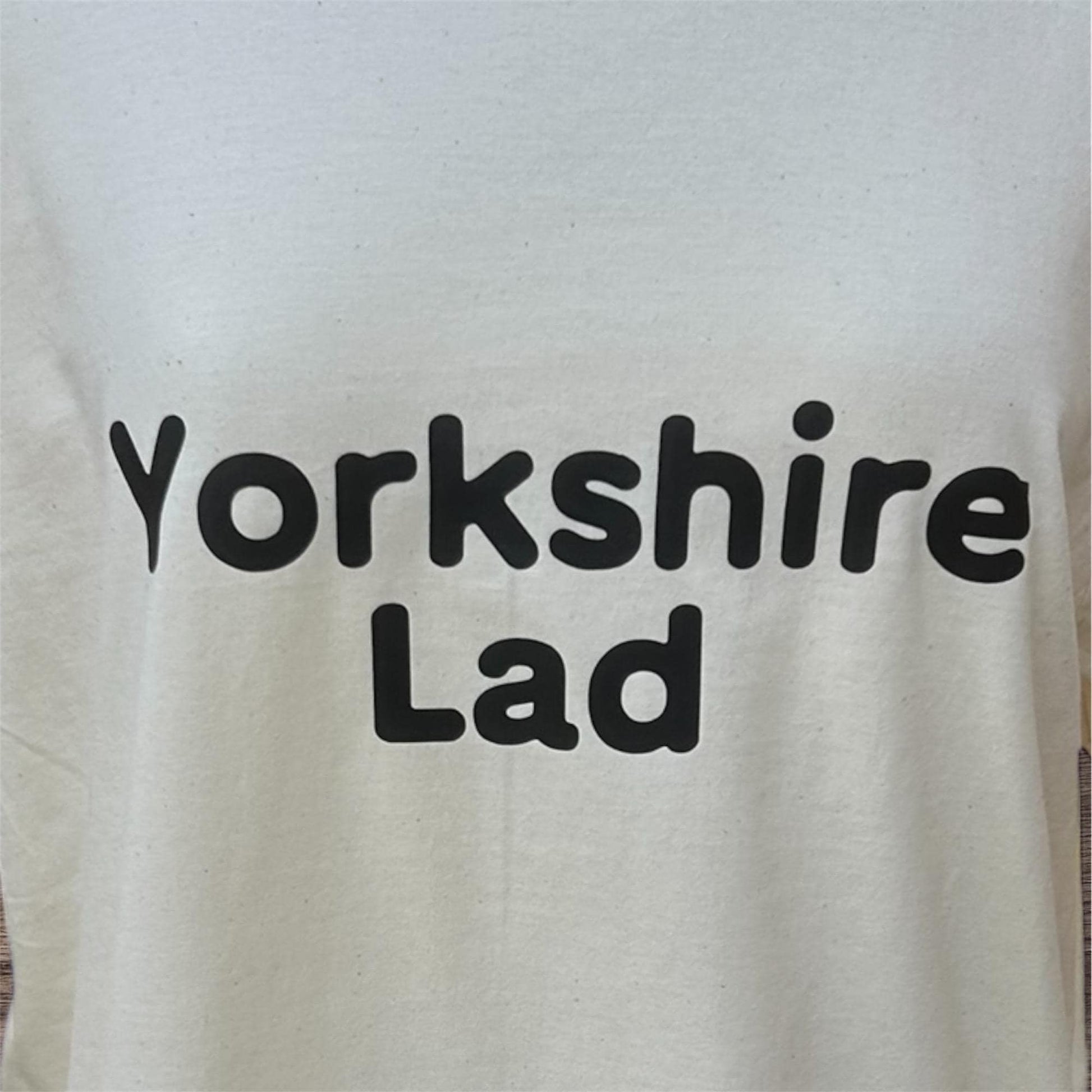 Cream shirt with 'Yorkshire Lad' text in black on a plain background