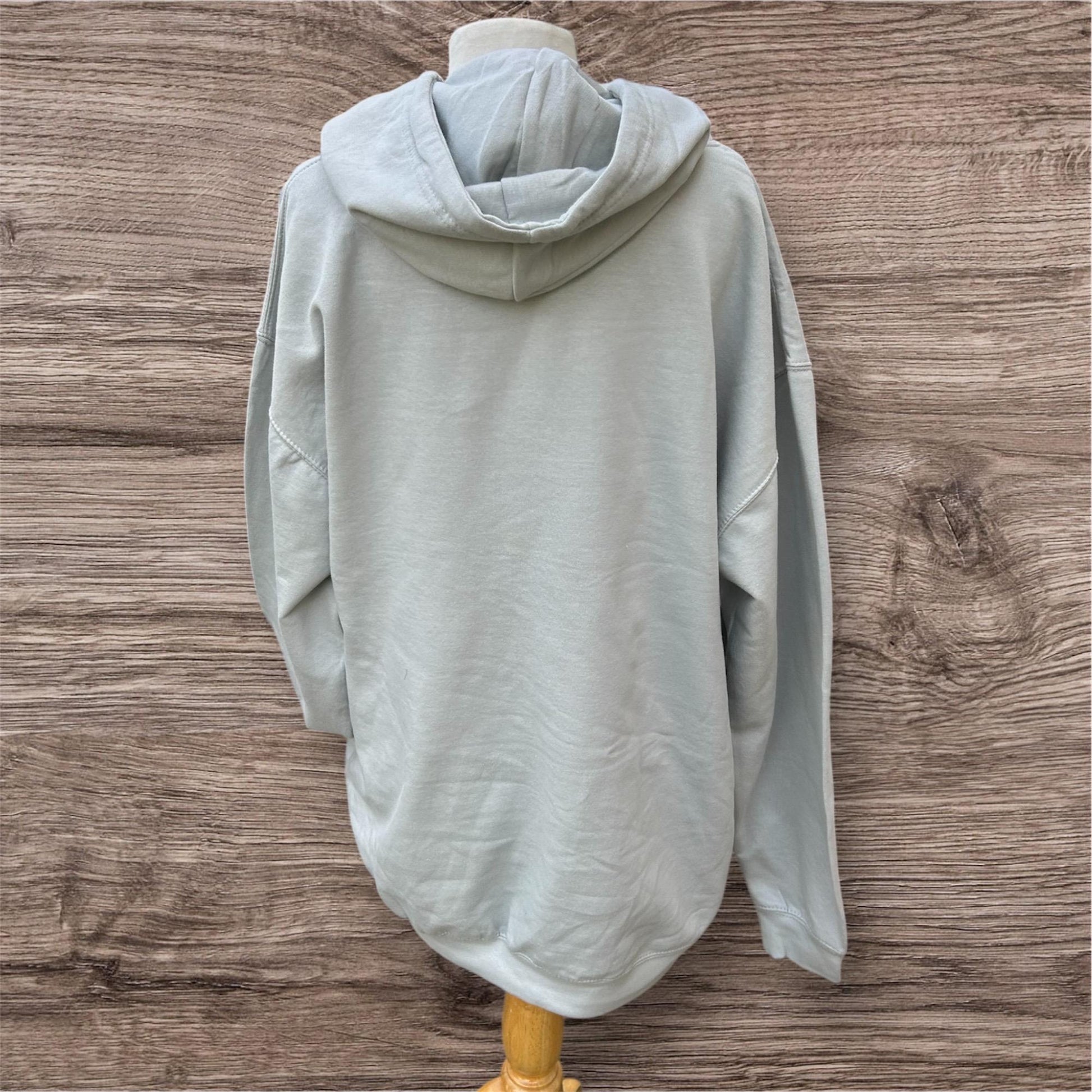 Light gray hoodie on a wooden mannequin with Yorlshire slang on the front